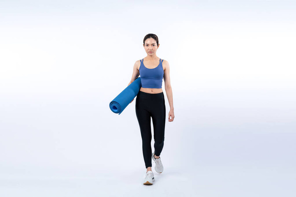 Jonge aantrekkelijke Aziatische vrouw portret in sportkleding met trainingsmat. Gezonde lichaamsbeweging en workout routine levensstijl concept. Studio schot geïsoleerde achtergrond. Krachtig - Foto, afbeelding