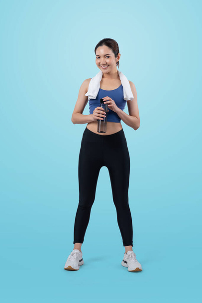 Athletic and sporty asian woman resting and drink water after intensive cardio workout training. Healthy exercising and fit body care lifestyle pursuit in studio shot isolated background. Vigorous - Photo, Image