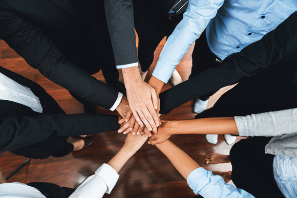 Wielorasowi biznesmeni tworzą synergiczny stos dłoni razem w sali konferencyjnej jako kooperacja lub budowanie zespołu dla pracowników korporacyjnych w miejscu pracy. Skrupulatny - Zdjęcie, obraz