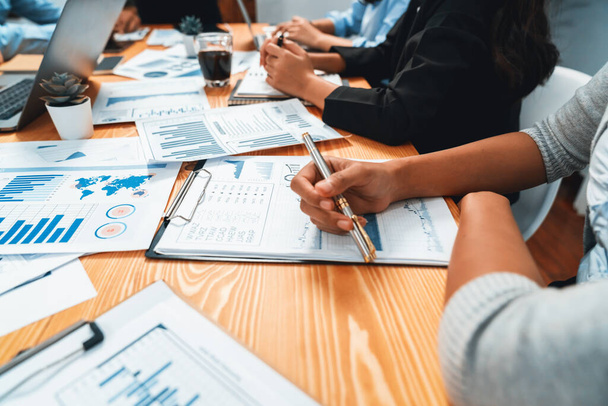 Diverse group of business analyst team analyzing financial data report paper on office table. Chart and graph dashboard by business intelligence analysis for strategic marketing planning Habiliment - Photo, Image