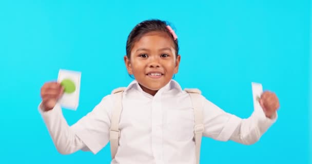 Happy, education and a girl with cards on a blue background for learning, studying and presentation. Creative, excited and face portrait of a girl or student with notes isolated on a backdrop. - Footage, Video