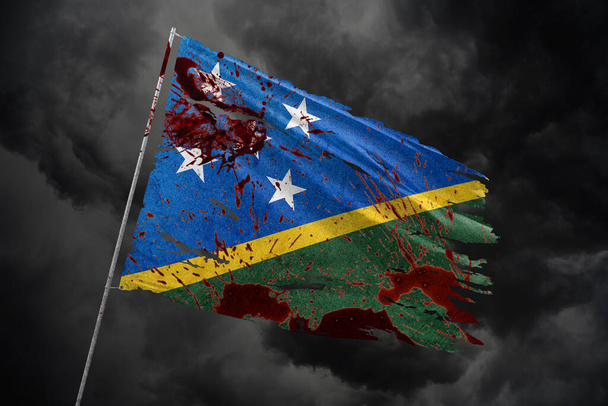 Islas Salomón rasgó la bandera en el fondo del cielo oscuro con manchas de sangre. - Foto, Imagen