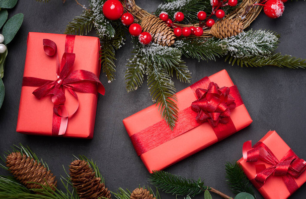 Couronnes de Noël, branches de sapin et cadeaux sur fond noir. Vue d'en haut - Photo, image
