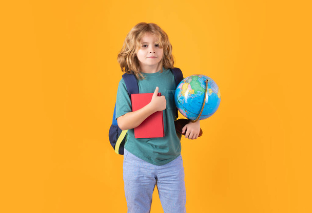 Kid enjoy school. School boy in school uniform with backpack on yellow isolated background. Kids learning knowledge and education concept - Photo, Image