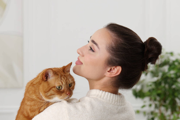 Beautiful woman with cute cat at home - Foto, afbeelding