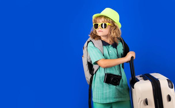 Child travel with travel bag. Child with suitcase dreams of travel, adventure, vacation. Studio kids portrait - Photo, Image