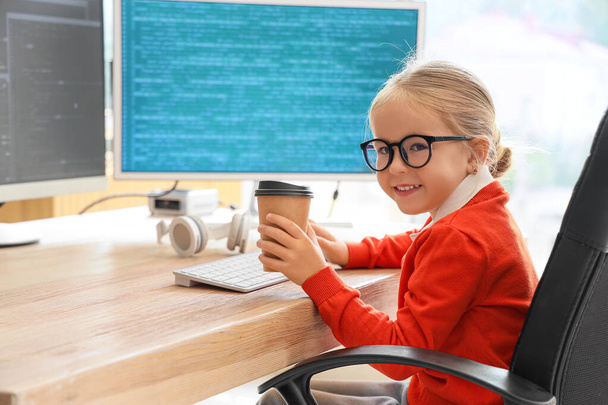 Cute little programmer girl with cup of coffee in office - Photo, Image