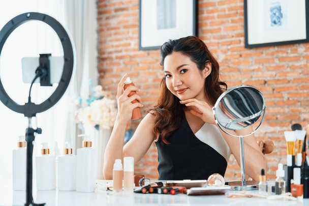 Woman influencer shoot live streaming vlog video review makeup uttermost social media or blog. Happy young girl with cosmetics studio lighting for marketing recording session broadcasting online. - Photo, Image