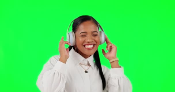 Happy woman, headphones and listening to music in dance on green screen against a studio background. Female person with smile and headset in happiness enjoying audio streaming or online sound track. - Footage, Video