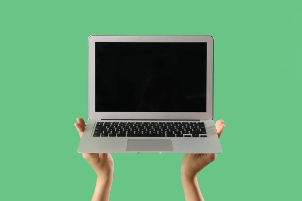 Vrouw met blanco laptop op groene achtergrond - Foto, afbeelding