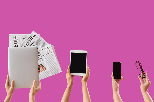 Mujeres con gadgets modernos, periódicos y anteojos sobre fondo púrpura - Foto, imagen