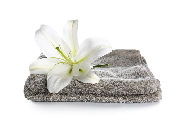 Чистое полотенце и красивый цветок лилии на белом фоне - Фото, изображение