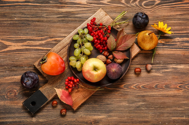 Board with different fresh fruits on wooden background - Photo, Image