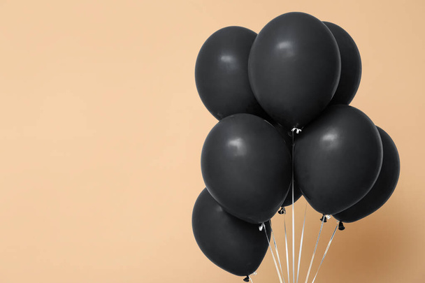 Balony pływające na beżowym tle. Wyprzedaż Black Friday - Zdjęcie, obraz