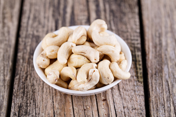 Cashews on a wooden background. - Foto, afbeelding