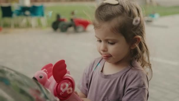 Krásná kavkazská holčička střílí bubliny z mýdlové bubliny pistole na dvorku domu. Letní den. Dětství. - Záběry, video