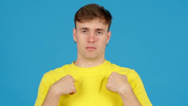 Teenager boy keeping a secret isolated on blue background. Young man doing silence or closing mouth gesture. - Footage, Video