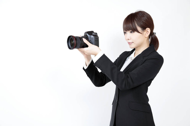 close-up portrait of beautiful young asian businesswoman in suit with camera isolated on white - Fotoğraf, Görsel