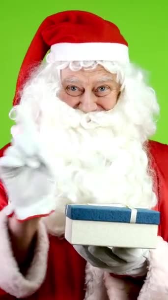 Nespokojený, skutečný Santa ukazuje, ale nedává dárek v krabici. Veselý Santa v červeném obleku během Vánoc. Zelená obrazovka. Chroma Key. Svisle. - Záběry, video