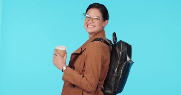 Utazás, kávé és hátizsák egy nő turista stúdió kék háttér városnézés vagy kaland. Portré, mosoly és szemüveg egy boldog fiatal nő iszik egy italt nyaralás közben. - Felvétel, videó