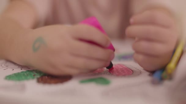 Schattig jong kind met gekleurde pennen en papieren tekening - Video