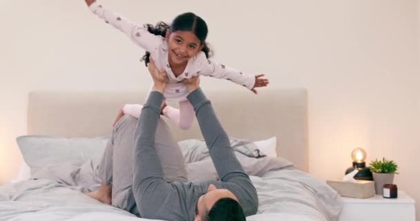 Happy, airplane and girl child with father on a bed for fun, games or bonding at home together. Flying, love and excited kid with parent in a bedroom with lifting, support and playing in a house. - Video, Çekim