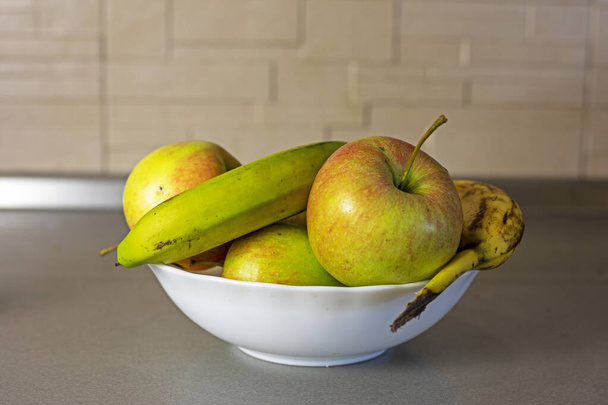 talerz z jabłkami i bananami w kuchni - Zdjęcie, obraz