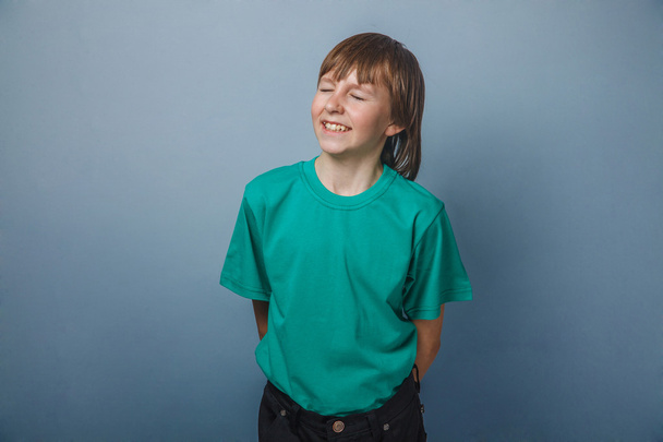 Αγόρι, έφηβος, δώδεκα χρόνια σε ένα πράσινο πουκάμισο, έκλεισε τα μάτια του - Φωτογραφία, εικόνα