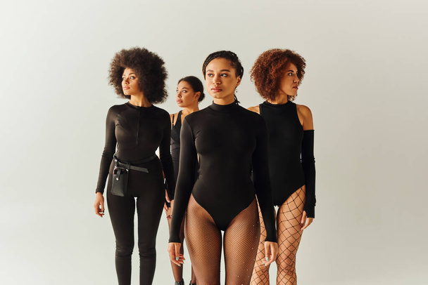 attractive young african american female friends in black appealing bodysuits, fashion concept - Photo, Image