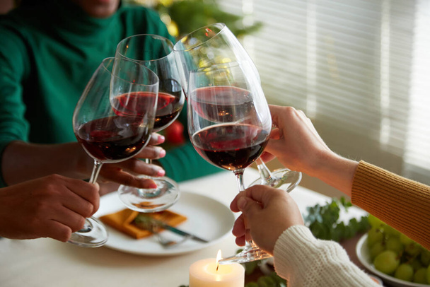 Groupe d'amis griller avec des verres d'hiver rouge, célébrer Noël à la maison - Photo, image