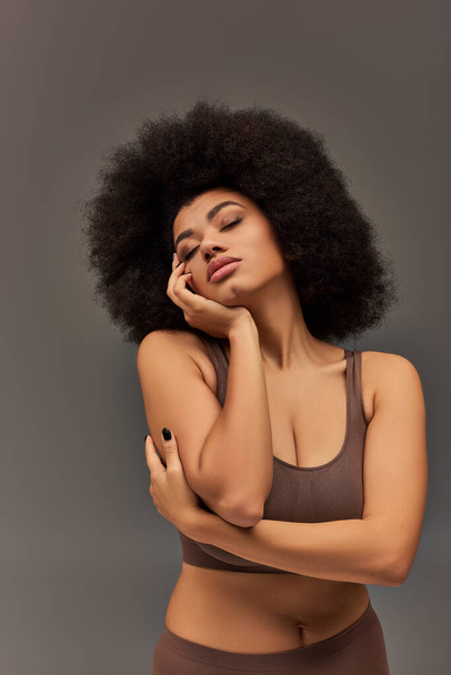 fiatal afro-amerikai nő pasztell fehérnemű fekete körömlakk pózol csábítóan, divat - Fotó, kép