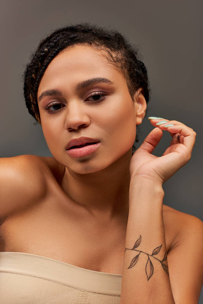 giovane donna afroamericana attraente in biancheria intima beige pastello posa sul serio, concetto di moda - Foto, immagini