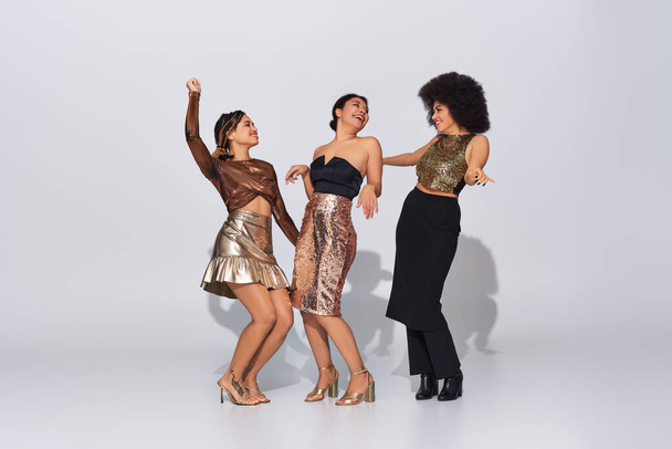 vreugdevolle Afrikaanse Amerikaanse vrouwen in feestelijke kleding met lovertjes feesten samen, mode concept - Foto, afbeelding