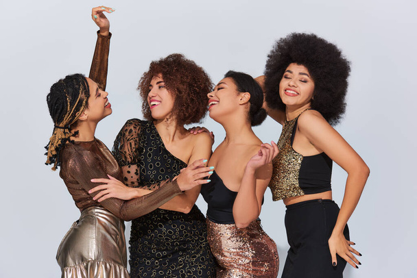 quatro atraentes jovens afro-americanas amigas festejando em trajes festivos, conceito de moda - Foto, Imagem