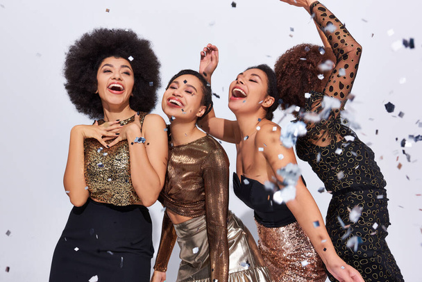 Güzel, şık Afro-Amerikan kadınları konfeti yağmuru ve moda altında canlı giysiler içinde parti yapıyorlar. - Fotoğraf, Görsel