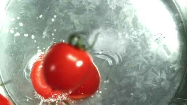 Οι ντομάτες πέφτουν σε ένα κουβά νερό. Τραβήχτηκε σε κάμερα υψηλής ταχύτητας στα 1000 fps. Υψηλής ποιότητας υλικό FullHD - Πλάνα, βίντεο