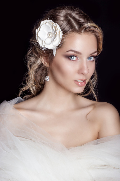 Retrato de hermosa mujer feliz novia suave en un vestido de novia blanco c hermoso pelo de la boda del salón con flores blancas en su pelo
 - Foto, Imagen