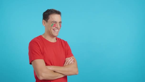 Vídeo em estúdio com croma de um homem feliz com bandeira portuguesa pintada no rosto olhando para o espaço de cópia em branco - Filmagem, Vídeo