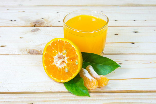 Vaso de delicioso zumo de naranja y rodajas de naranja en t de madera
 - Foto, Imagen