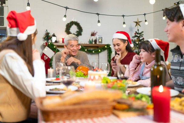 Bella famiglia felice riuniti intorno al tavolo, avendo cena di Natale, godersi la stagione delle vacanze invernali e il loro tempo insieme - Foto, immagini