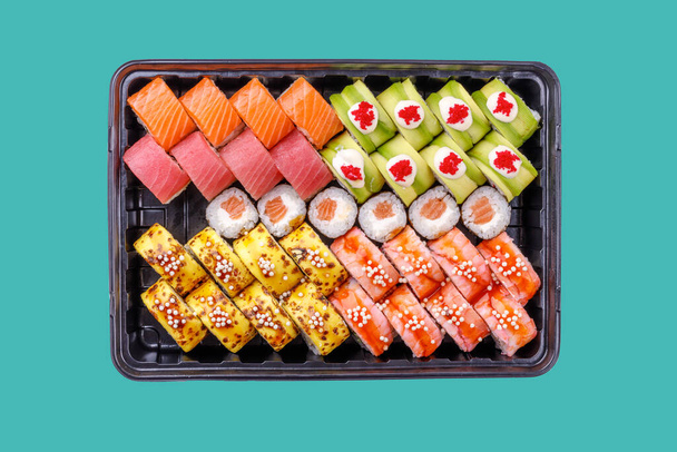 gran conjunto de rollos y maki con salmón y camarones sobre un fondo verde - Foto, Imagen