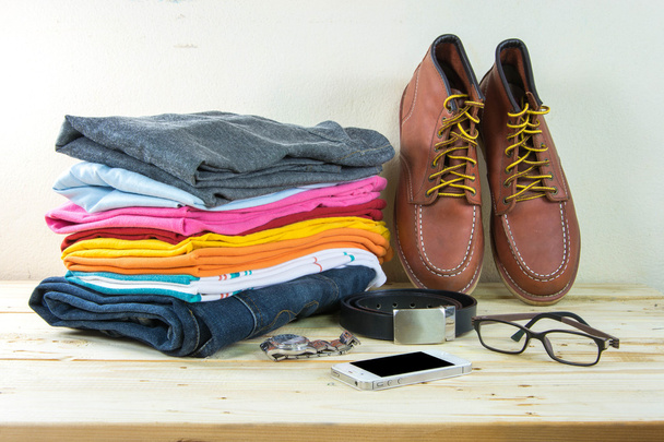 Martwa natura z plaid shirt, dżinsy, brązowe buty na drewnianym stole  - Zdjęcie, obraz