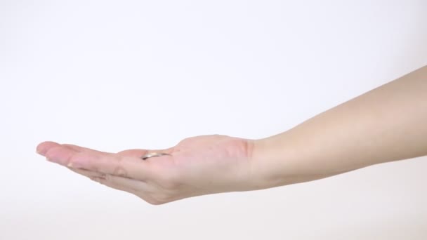 Egy nő elkapja a zuhanó érmét fordított időben. Egy nő kinyújtott keze egy érmét fog, és 4k fordított időt mutat. - Felvétel, videó