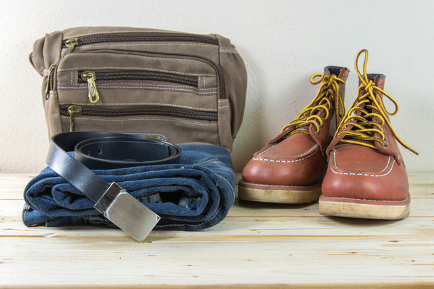 Still life with plaid shirt, jeans, bruine laarzen en tas op woode - Foto, afbeelding