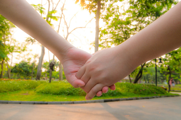 Paar hand houden in zonsondergang - Foto, afbeelding