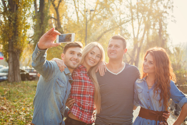 Friends are photographed with a smartphone in the Park. - Fotoğraf, Görsel