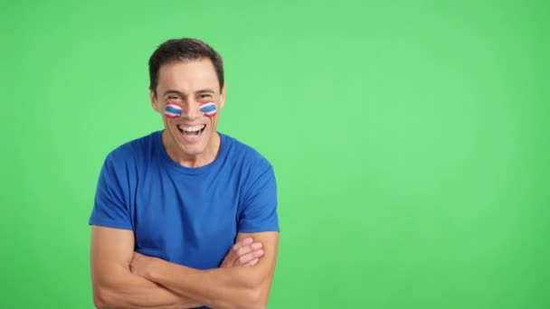 Vídeo em estúdio com croma de um homem de pé com bandeira tahi pintado no rosto sorrindo com os braços cruzados - Filmagem, Vídeo