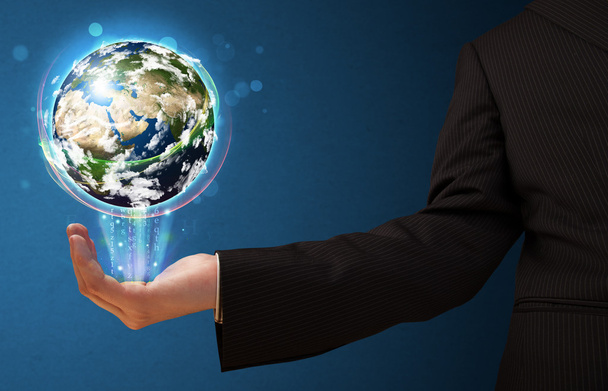 Бизнесмен, держащий светящийся земной шар - Фото, изображение