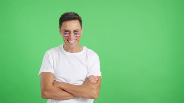 Vídeo em estúdio com croma de um homem de pé com a bandeira dos Estados Unidos pintado no rosto sorrindo com os braços cruzados - Filmagem, Vídeo