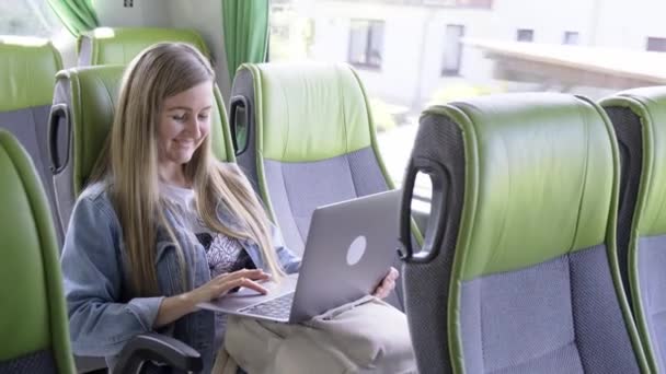 Günlük giysiler içinde mutlu genç bir kadın, video görüntüleriyle arkadaşlarıyla konuşuyor, gülümsüyor ve Avrupa 'da turistik bir şehir otobüsü turunda oturuyor.. - Video, Çekim